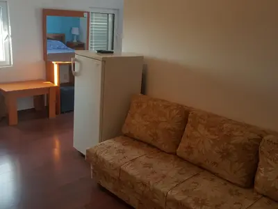 a living room with a couch and a refrigerator at Buljarica Bay Apartments in Petrovac na Moru