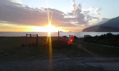 a sunset over the ocean with the sun shining at Buljarica Bay Apartments in Petrovac na Moru