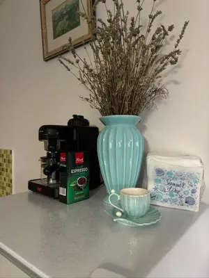 a blue vase sitting on a counter with a cup of coffee at Vila Vujošević in Utjeha