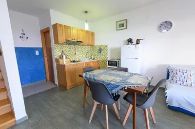 a kitchen and dining room with a table and chairs at Vila Vujošević in Utjeha