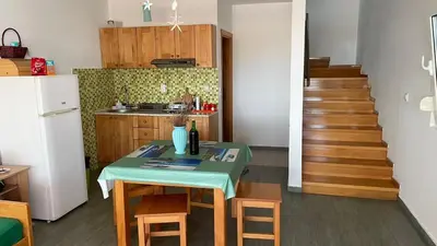 a kitchen with a table and a kitchen with a staircase at Vila Vujošević in Utjeha