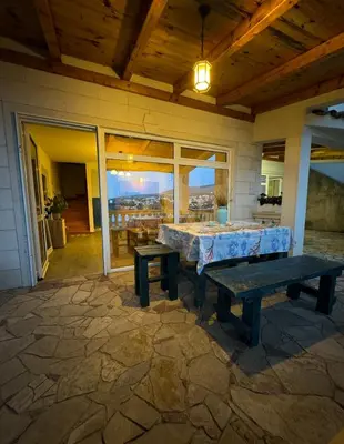 a patio with a table and benches on a house at Vila Vujošević in Utjeha