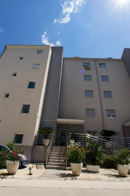 a building with stairs and plants in front of it at Peace 2 Apartments with parking in Budva