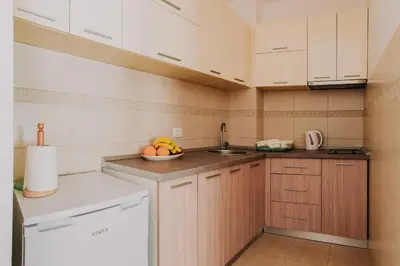 a kitchen with white cabinets and a bowl of fruit at Peace 2 Apartments with parking in Budva