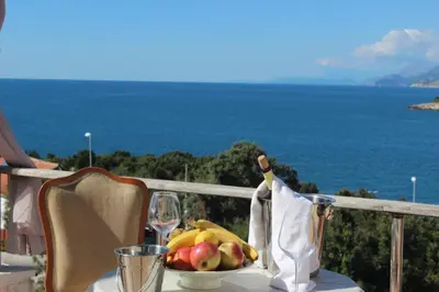 a table with a bowl of fruit and a glass of wine at Apartment Carpe Diem 1 in Utjeha