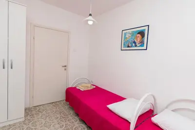a white room with a red bed and two white chairs at Apartment Carpe Diem 1 in Utjeha