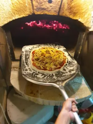 a person taking a pizza out of an oven at Apartment Carpe Diem 1 in Utjeha