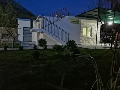 a house with a staircase in the yard at night at Apartman Nikocevic in Dobra Voda