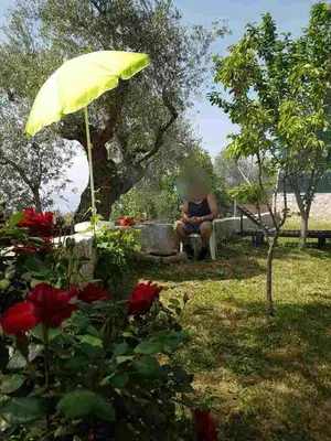 a person sitting in a chair under a yellow umbrella at Apartman Nikocevic in Dobra Voda