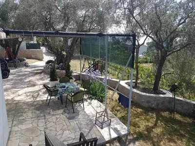 a patio with a table and chairs under a canopy at Apartman Nikocevic in Dobra Voda