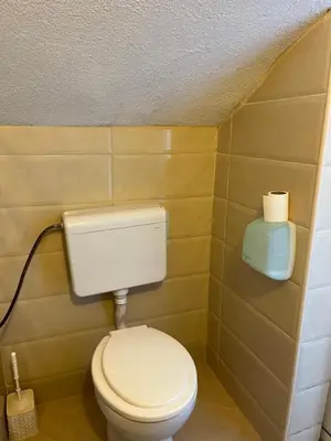 a bathroom with a toilet and a roll of toilet paper at Apartments Feniks in Ulcinj