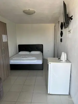 a small bedroom with a bed and a white table at Apartments Feniks in Ulcinj