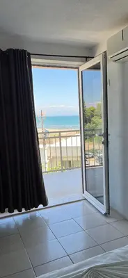 a room with a sliding glass door with a view of the beach at Apartments Feniks in Ulcinj