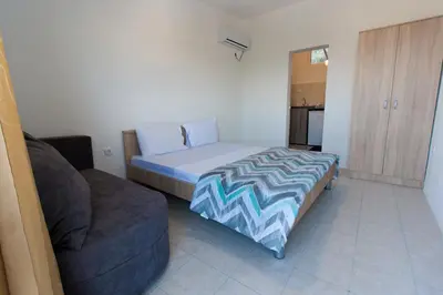 a small bedroom with a bed and a couch at Apartments Feniks in Ulcinj