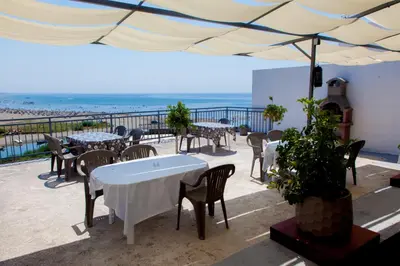a patio with tables and chairs and a view of the beach at Apartments Feniks in Ulcinj
