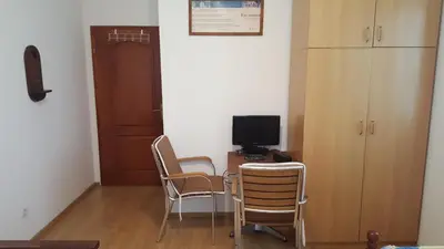 a room with chairs and a desk with a television at Room 4 U in Bar