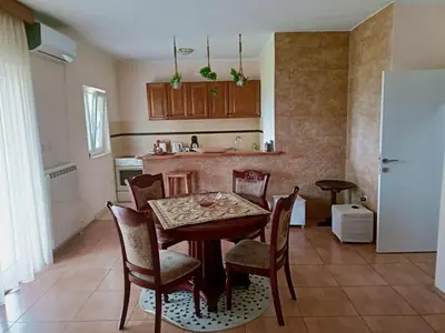 a kitchen with a table and chairs in a room at Green Silence - Vuk in Podgorica