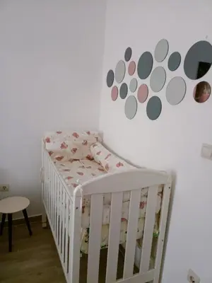 a white crib in a room with a wall at Green Silence - Vuk in Podgorica