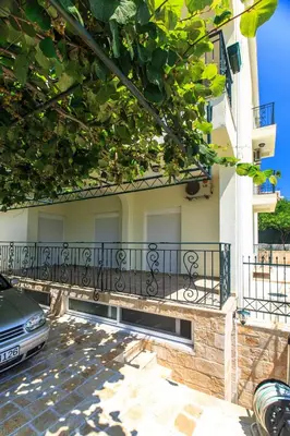a balcony of a building with a car parked next to it at Apartments Aleksić in Bar