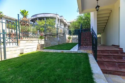 a house with a yard with green grass at Apartments Aleksić in Bar