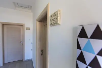 a hallway with a door and a sign on a wall at Apartments Aleksić in Bar
