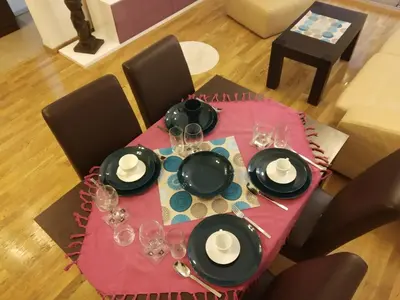 a table with plates and wine glasses on top of it at Apartments Svilen Konac in Budva