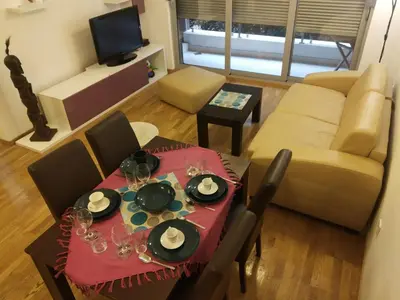 a living room with a table and a couch at Apartments Svilen Konac in Budva