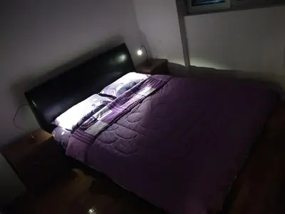 a bed with a purple comforter in a bedroom at Apartments Svilen Konac in Budva