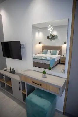 a bedroom with a mirror and a bed and a desk at Apartments Cota Guesthouse in Ulcinj
