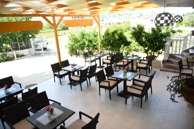 an outdoor restaurant with tables and chairs at Apartments Cota Guesthouse in Ulcinj