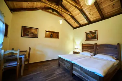 a bedroom with a bed and a table and a dining room at Eco Resort Cermeniza in Virpazar