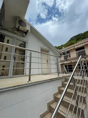 a balcony of a house with stairs in front at Apartment Crocus of Rafailovici in Budva