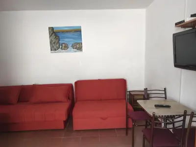 a living room with a red couch and a table at Apartmani Grozdanic Canj in Čanj