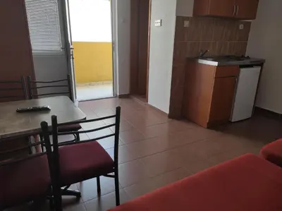 a kitchen and dining room with a table and chairs at Apartmani Grozdanic Canj in Čanj