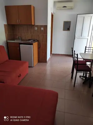 a living room with a red couch and a table at Apartmani Grozdanic Canj in Čanj