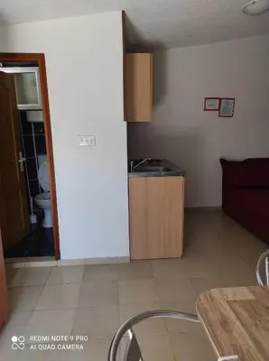 a kitchen and a living room with a couch and a table at Apartmani Grozdanic Canj in Čanj