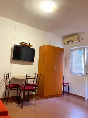 a room with a table and chairs and a cabinet at Apartmani Grozdanic Canj in Čanj