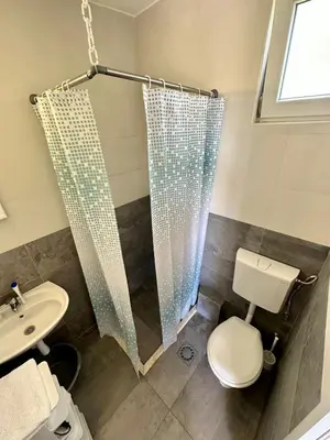 a bathroom with a shower and a toilet and a sink at Montenegrina Apartment in Budva