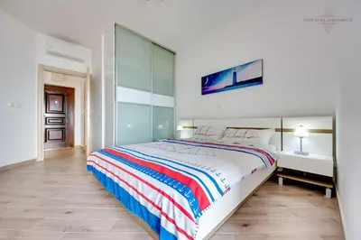 a bedroom with a large bed and a desk at Sveti Luka Apartments in Dobra Voda