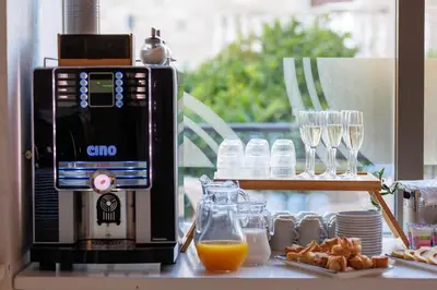 a coffee machine sitting on a counter with glasses of orange juice at Hotel Kadmo by Aycon in Budva