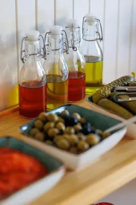 a table with bottles of oil and plates of olives at Hotel Kadmo by Aycon in Budva