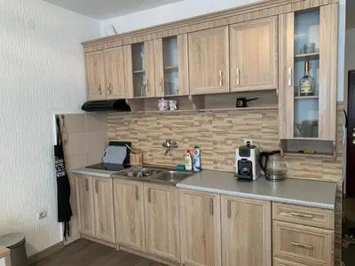 a kitchen with wooden cabinets and a sink at Apartman Glava Zete in Sutomore