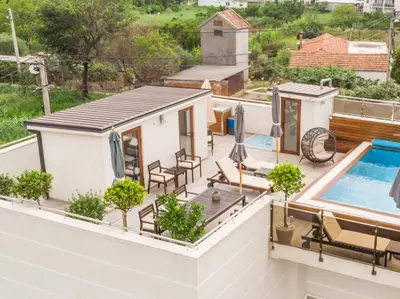 a balcony with a swimming pool and a house at Apartments Davor in Bar