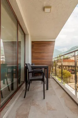 a balcony with a table and a chair on it at Apartments Davor in Bar