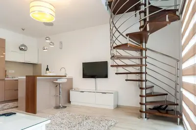 a spiral staircase in a living room with a television at Apartments Davor in Bar