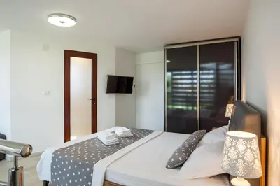 a bedroom with a large bed with a television on it at Apartments Davor in Bar