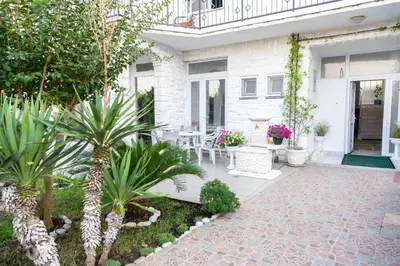 a patio with chairs and plants on a house at Guest House Aldin in Ulcinj