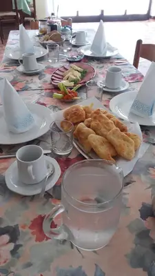 a table with plates of food and cups on it at Guest House Aldin in Ulcinj