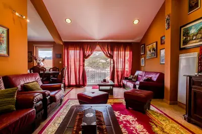 a living room with red furniture and a large window at Apartments Varja in Sveti Stefan