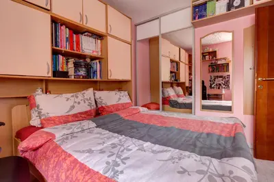 a bedroom with a bed and a mirror and bookshelves at Apartments Varja in Sveti Stefan